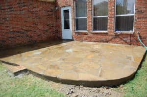 Stamped concrete stone patio next to brick home